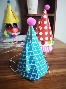 Detail of colorful polka dot and plaid paper party hats with soft pom poms and elastic strings
