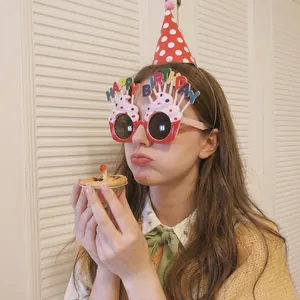 Child wearing red polka dot party hat and happy birthday glasses for celebration