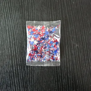 Primer plano de lentejuelas de estrellas rojas azules y plateadas para decorar fiestas