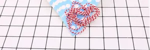 Dettaglio di bandierine triangolari blu a pois con corda di cotone bianco e rosso decorativa
