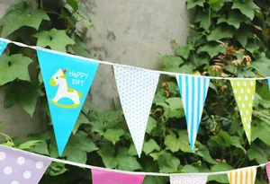 Detail of colorful triangle bunting banner with rocking horse and Happy Day text for parties