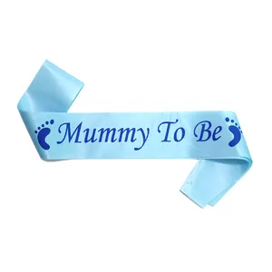 Close-up of light blue satin Mummy To Be sash with dark blue lettering and baby footprints