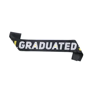Detalle de banda de graduación en satén negro con texto blanco e iconos amarillos