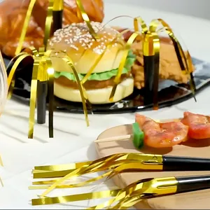 Golden foil fringed party blowouts set displayed with festive food on a dining table