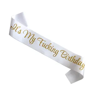 Close-up of white satin sash with gold glitter It's My Fucking Birthday lettering