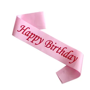 Detailed view of pink satin Happy Birthday sash with red lettering and silk texture
