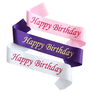 Close-up of three satin birthday sashes in pink, purple, and white with elegant lettering