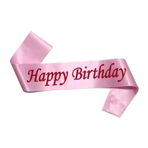 Close-up of a pink satin sash with cursive Happy Birthday lettering in deep red font