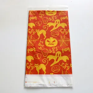 Detail of Halloween plastic bag featuring cartoon ghosts, pumpkins, and skeletons on orange background