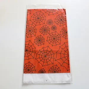 Detailed view of orange Halloween tablecloth with spider web pattern in PE packaging