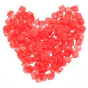 Red silk artificial rose petals arranged in a heart shape for romantic decor