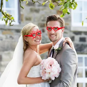 Vue détaillée de lunettes de fête en cœur rouge avec texte Hug Me pour accessoires photo