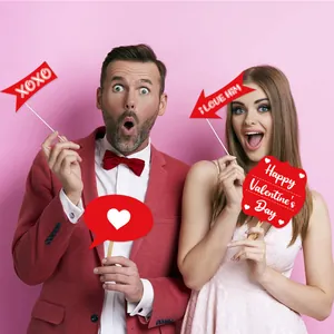Close-up of Valentine's Day party photo booth props featuring romantic signs and arrows