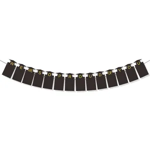 Detail of black mortarboard graduation banner with gold We Are So Proud Of You lettering