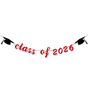 Macro detail of red glitter Class of 2026 banner with black graduation cap icons