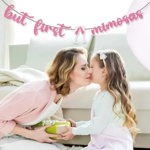 Pink glitter 'but first mimosas' party banner decoration with champagne glasses for Mother's Day