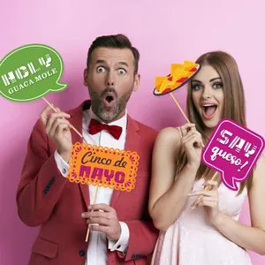 Cheerful models using Cinco de Mayo photo booth props with colorful party signs and nachos