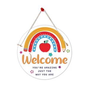 Detail view of round Welcome sign featuring rainbow pencils and motivational quote