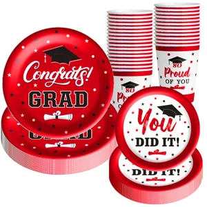 Detail of graduation party tableware set including paper plates and cups with congrats motifs