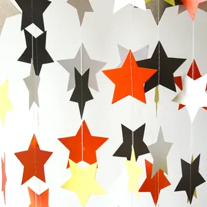 Close-up of star garland with black, orange and white paper stars for party decoration
