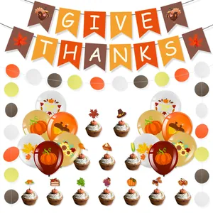 Macro detail of Thanksgiving party kit with GIVE THANKS banner and pumpkin cake toppers