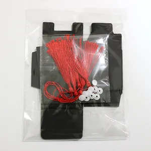 Λεπτομέρεια σετ DIY με κόκκινες φούντες, λευκά πλαστικά κουμπιά και μαύρο χαρτόνι