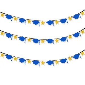 Close-up of blue graduation cap banners and gold glitter stars party decorations