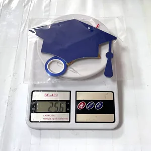 Close-up of blue graduation party decoration kit on electronic scale weighing 25.6g