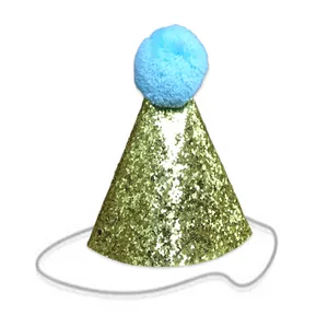 Detail of golden sequined pet birthday hat with a light blue pompom and elastic strap