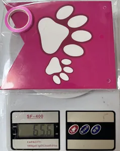 Detail view of pink paw print party banner and ribbon on scale weighing 65.6g