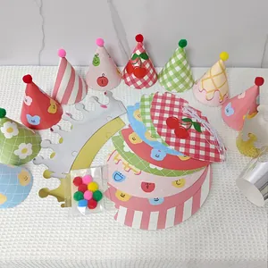 Flat lay showing various colorful cartoon party hats with pom-poms and crown designs