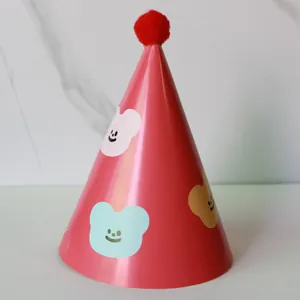 Detail of red party hat with fuzzy pom-pom and three cute bear patches for kids