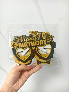 Detailed view of black and gold 70th birthday party paper glasses with glitter finish