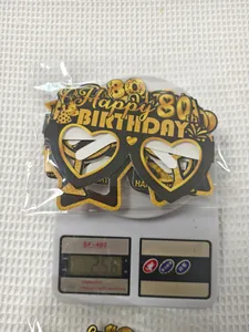 Detail shot showing 80th birthday party photo props being weighed at 25.6g on a scale