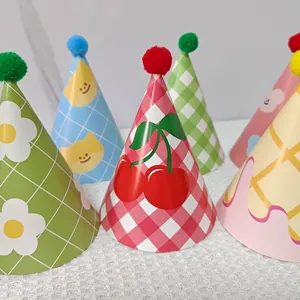 Close-up of assorted kids birthday party cone hats with pom-poms and cute grid patterns