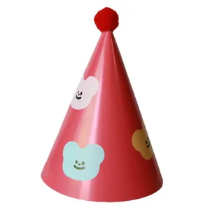 Red cone birthday hat for kids featuring colorful cartoon animals and a fluffy pompom top