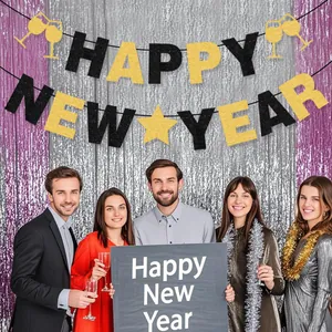 Detailaufnahme der schwarz-goldenen Happy New Year Banner mit Partyhintergrund und Modellen