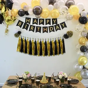 Détail de la bannière Happy Birthday noir et or avec guirlande de glands métalliques chic