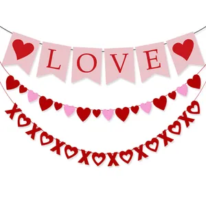 Close-up of Valentine's Day party banners with pink LOVE flag, heart strings and red XOXO signs