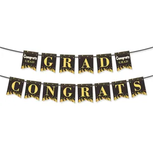 Detail of black and gold graduation banner showing Congrats Grad letters and silhouettes