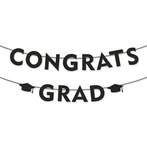 Detail eines schwarzen Glitzer Congrats Grad Banners mit Doktorhut-Motiven vor weißem Hintergrund