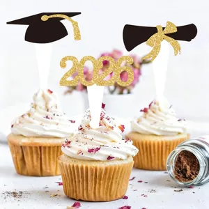 Close-up of 2026 graduation cupcake toppers with golden glitter cap and diploma designs