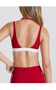 Dettaglio del design incrociato sulla schiena del reggiseno yoga rosso con fascia elastica
