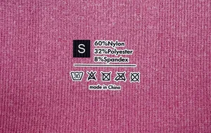 Detail showing printed size S tag and fabric composition on pink yoga shorts