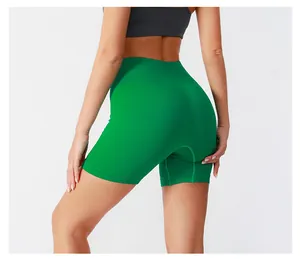 Detail of high waisted green ribbed yoga shorts showing seamless texture and fit