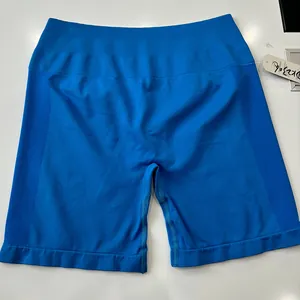 Detail van blauwe naadloze sportshort met hoge taille, geribbelde band en honingraatstructuur
