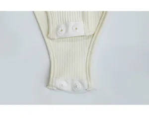 Close-up of ribbed fabric texture and snap button fasteners on the baby jumpsuit
