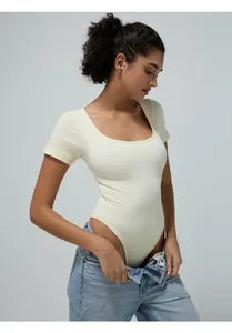 Close-up of seamless ribbed bodysuit in light yellow featuring a scoop neck and slim fit