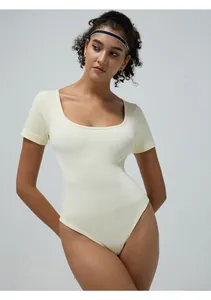 Close-up of cream ribbed texture and square neckline of the seamless yoga bodysuit