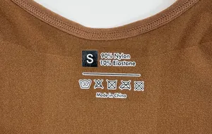 Close-up of heat-transfer label on brown yoga bodysuit showing S size and fabric composition